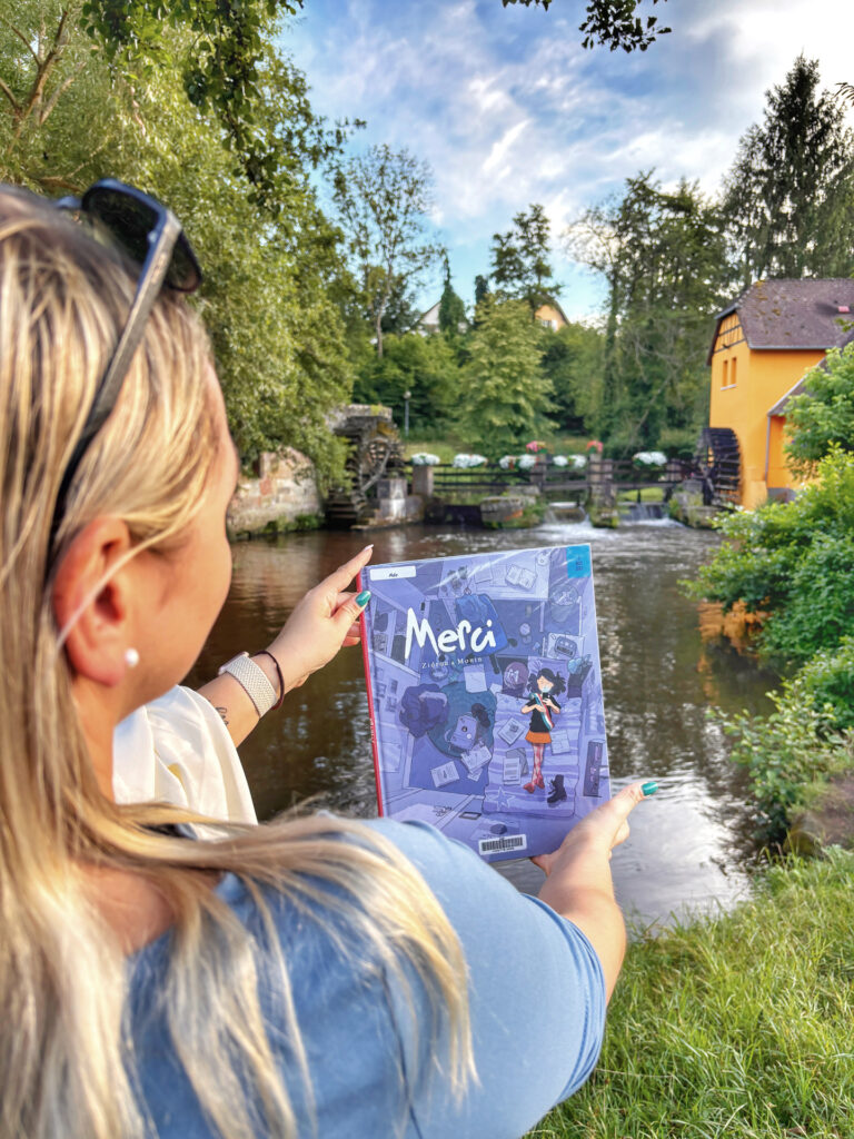 Sorbet Kiwi de dos tenant la BD Merci de Zidrou devant le Moulin de la Walck à Wissembourg