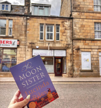 Main tenant The Moon Sister, la version originale de La soeur de la lune de Lucinda Riley devant le bureau de poste de Tain