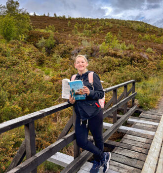 Sorbet-Kiwi tenant La soeur de la lune sur un pont en bois d'Alladale