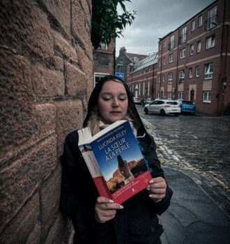 Lecture de La sœur à la perle de Lucinda Riley dans une ruelle étroite et pavée de Leith, sous la pluie écossaise – Sur les traces des Sept Sœurs.