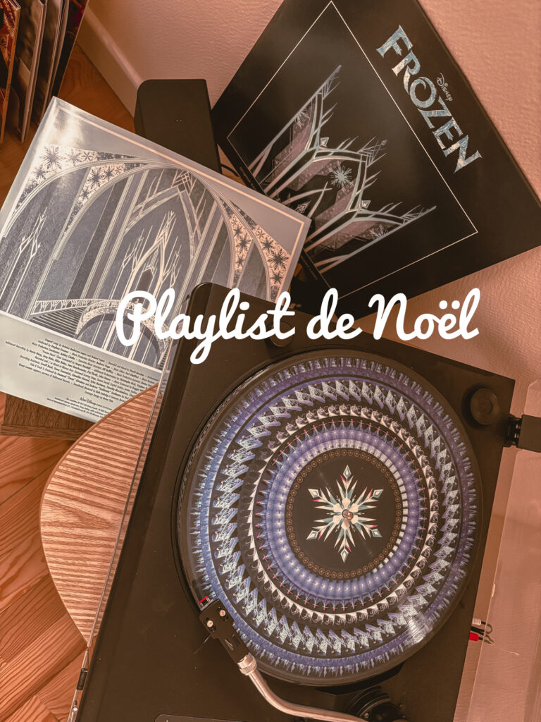 Un tourne-disque sur une table en bois fait jouer un vinyle de La reine des neiges décoré d’un grand flocon bleu et blanc. Autour, plusieurs pochettes du film Frozen sont posées, dont une montrant des arches glacées. Un meuble à vinyles apparaît sur le côté.