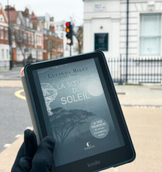 Kindle affichant La sœur du Soleil de Lucinda Riley tenu à la main sur Harvey Street, Londres.