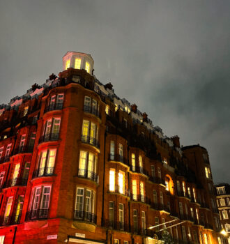 Façade illuminée de l’hôtel Claridge’s à Londres de nuit, décorée pour Noël, dans le cadre des traces d’Atlas.