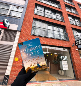 The Shadow Sister de Lucinda Riley devant un immeuble moderne au 188 Kensington Church Street à Londres, emplacement imaginé de la boutique d’Orlando dans la saga.