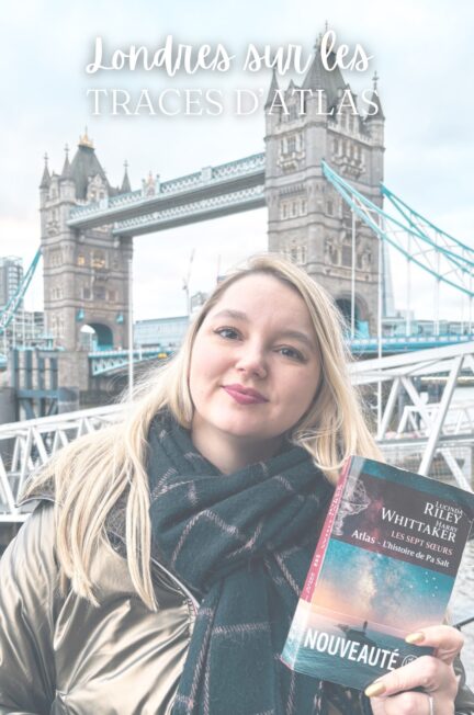 Stéphanie tenant le roman Atlas, l’histoire de Pa Salt devant Tower Bridge à Londres dans le cadre des traces d’Atlas.