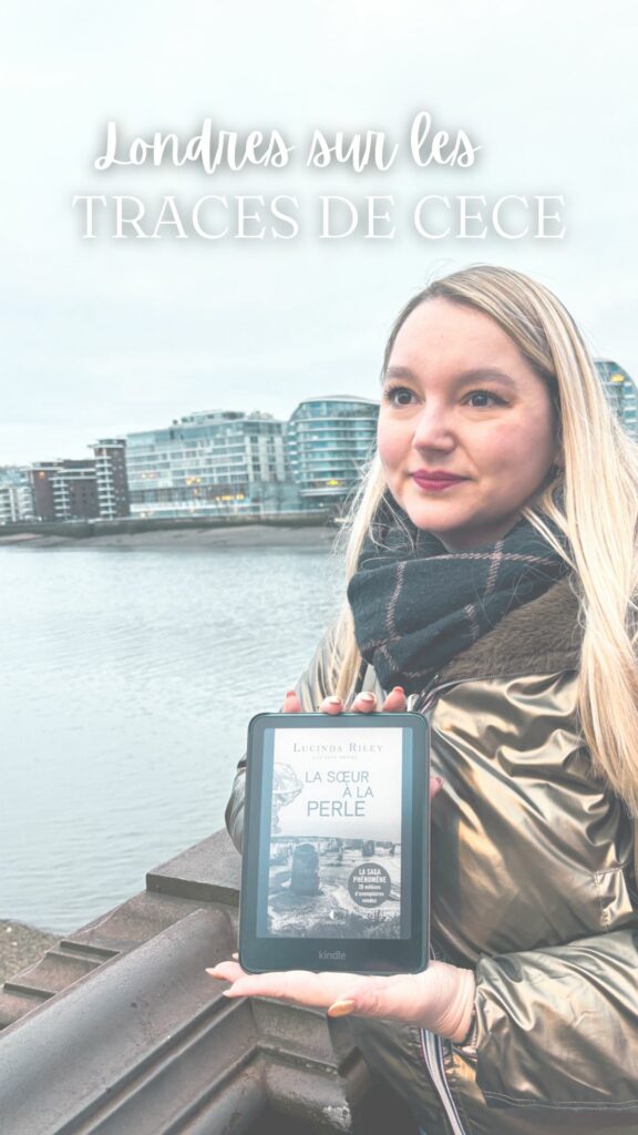 Stéphanie tenant une liseuse Kindle affichant La sœur à la perle de Lucinda Riley, au bord de la Tamise à Battersea à Londres, dans le cadre des traces de CeCe.