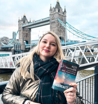 Stéphanie tenant Atlas, l’histoire de Pa Salt devant Tower Bridge et la Tamise à Londres.