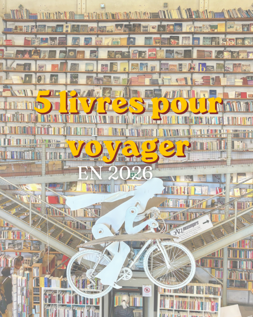 Immense librairie de Lisbonne aux rayonnages remplis de livres avec une sculpture de cycliste suspendue, illustrant une sélection de cinq romans pour voyager durant l'été.