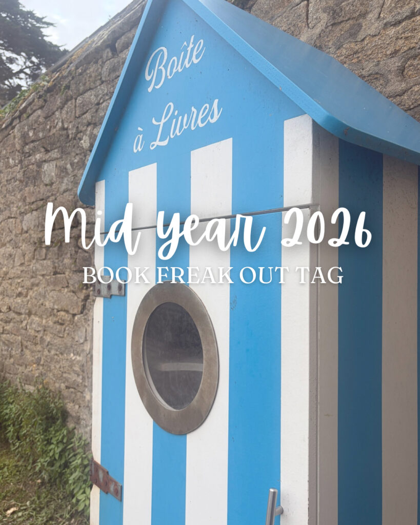 Boite à livres bleue et blanche photographiée en contre-plongée devant un mur en pierre à Douarnenez, avec le texte Mid Year 2026 Book Freak Out Tag superposé à l'image.