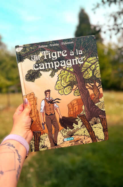 La bande dessinée Un tigre à la campagne de Nicolas Antona, Olivier Aranda et Mylenium photographiée dans un jardin, devant un paysage verdoyant.