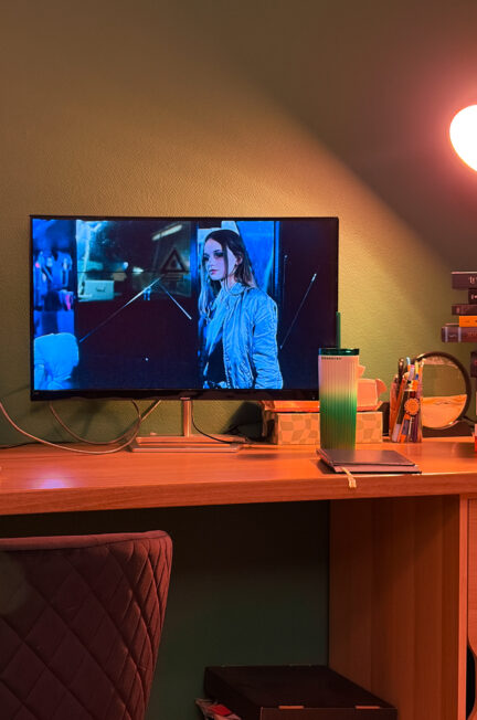 Écran diffusant le film Christiane F., 13 ans, droguée, prostituée de 1981, installé sur un bureau dans une pièce éclairée en orange.