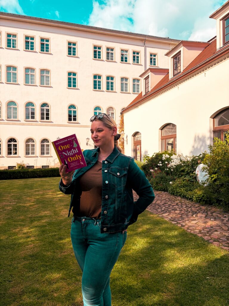 Sorbet-Kiwi tenant le roman One Night Only de Catherine Walsh dans la cour d’un bâtiment historique : la maison Felix Mendelssohn de Leipzig.
