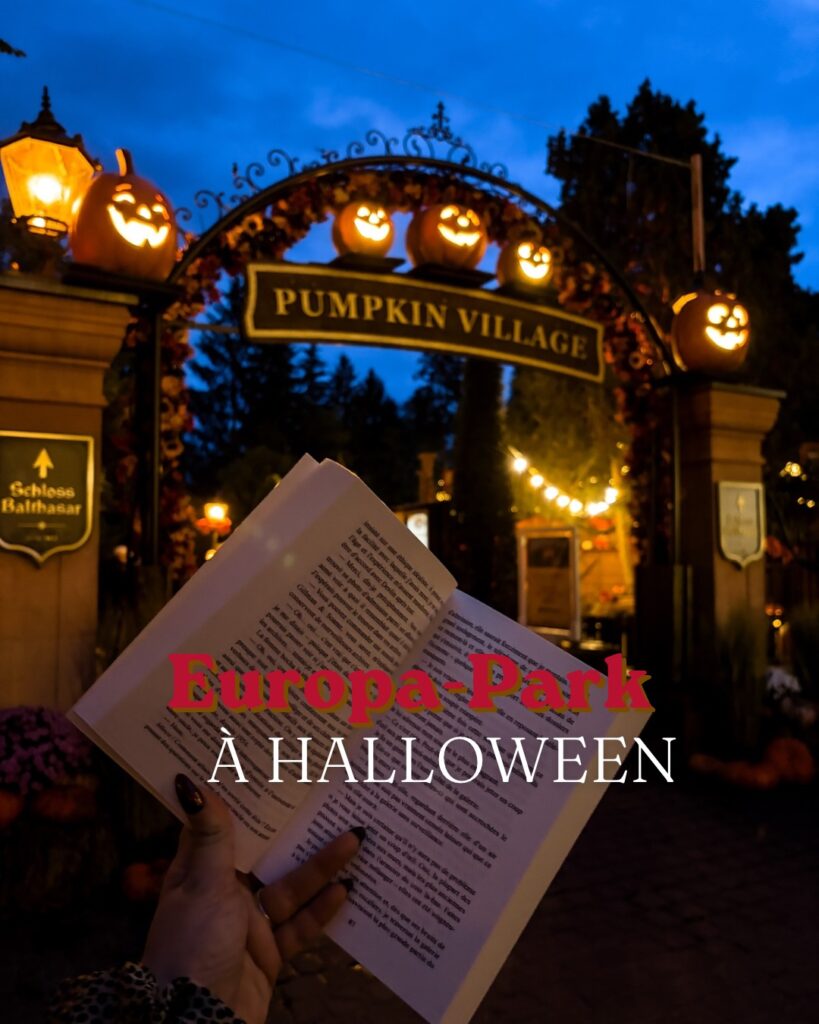 Photographie prise à Europa-Park pendant la saison d'Halloween 2026, à la tombée de la nuit. Au premier plan, une main tient un livre ouvert devant l'entrée du Pumpkin Village. L'arche décorative est ornée de citrouilles souriantes illuminées et de guirlandes automnales. À l'arrière-plan, les lumières du parc contrastent avec le ciel bleu profond. Le texte « Europa-Park à Halloween » est superposé à la photographie en rouge et blanc pour illustrer l'article de blog consacré à cette visite.